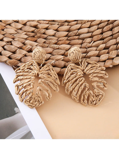 Pair of raffia woven hollow leaf shaped earrings shown from the back side