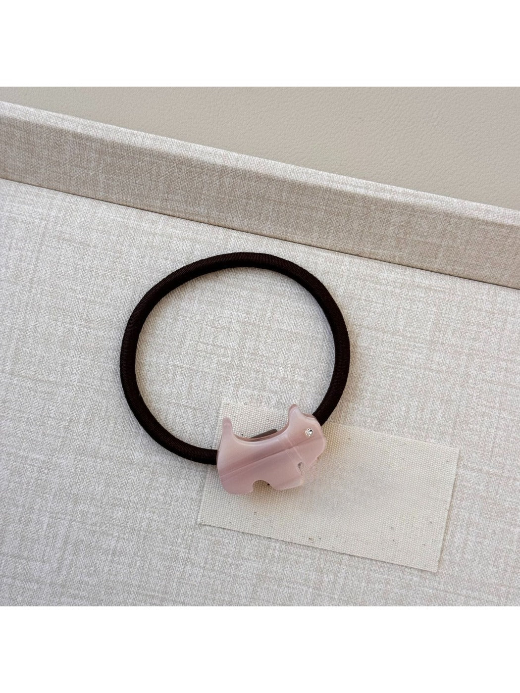 Top view of Gifty cartoon puppy hair tie with multicolored beads on elastic band