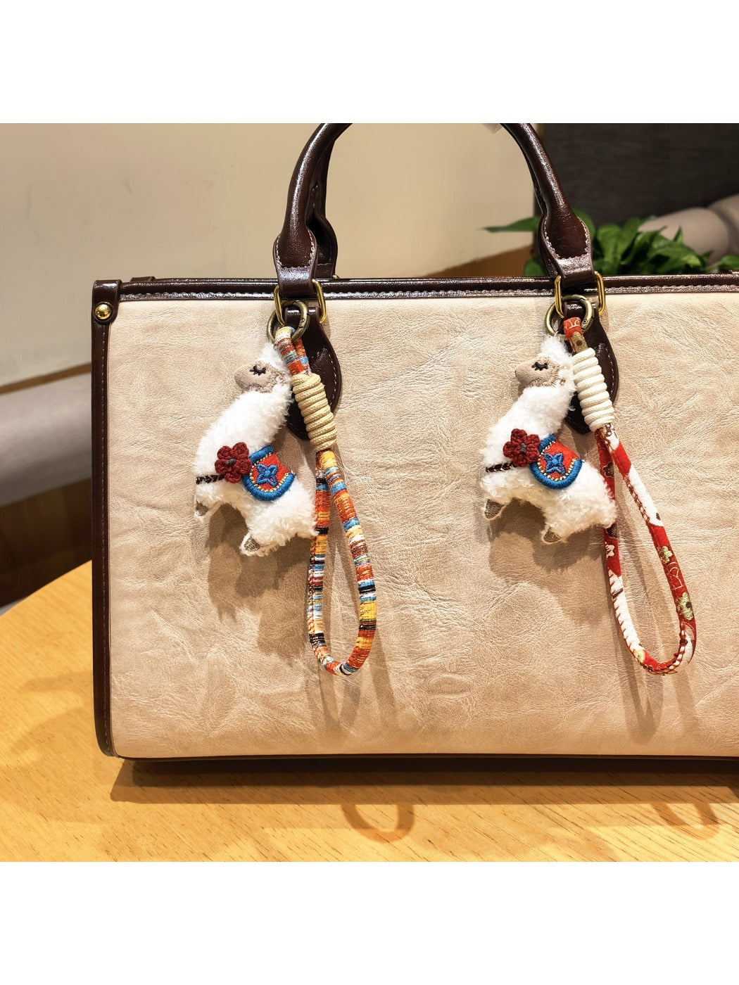 Close-up of a cute alpaca charm keychain with soft fur and a smiling face