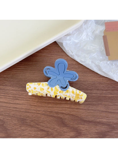 Beau flower shaped claw clip held in hand showing size and shape