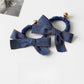 Close-up of vintage bow hair tie in soft pink fabric with textured pattern