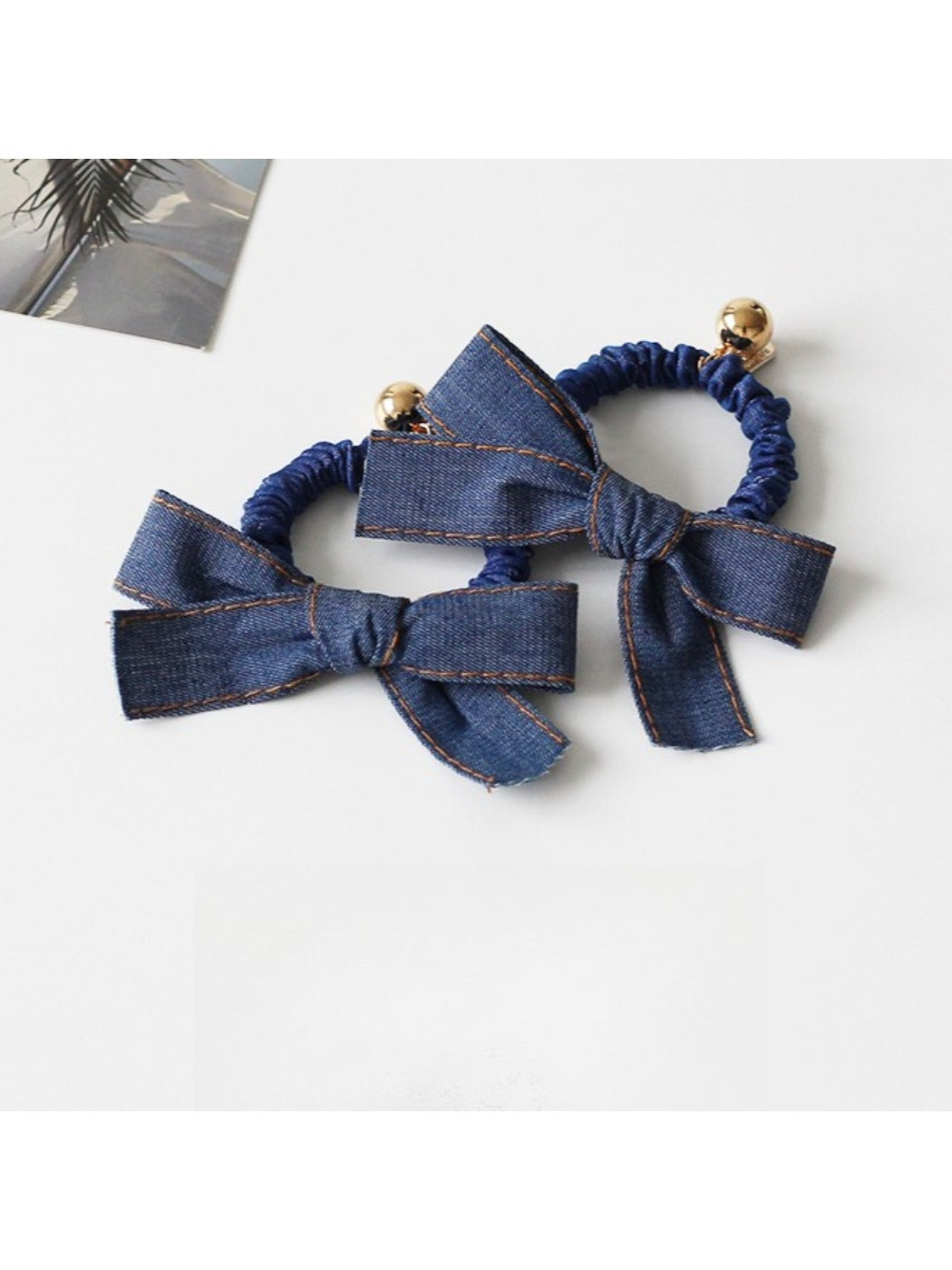 Close-up of vintage bow hair tie in soft pink fabric with textured pattern