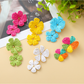 Close-up of Earedge floral pendant raffia drop earrings on white background