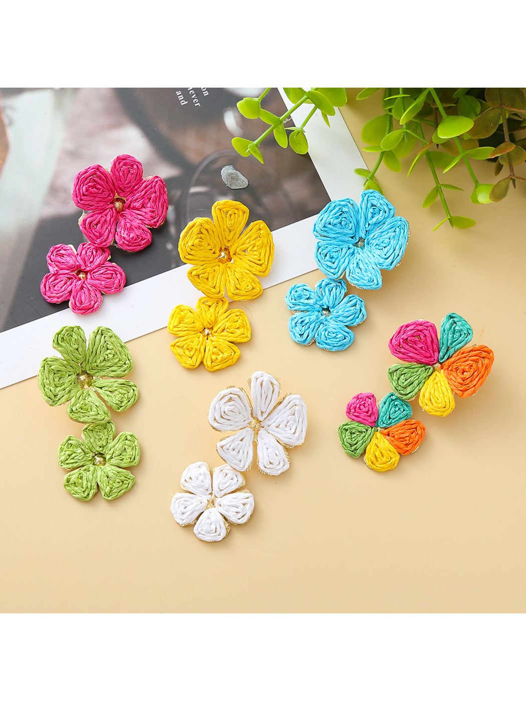 Close-up of Earedge floral pendant raffia drop earrings on white background