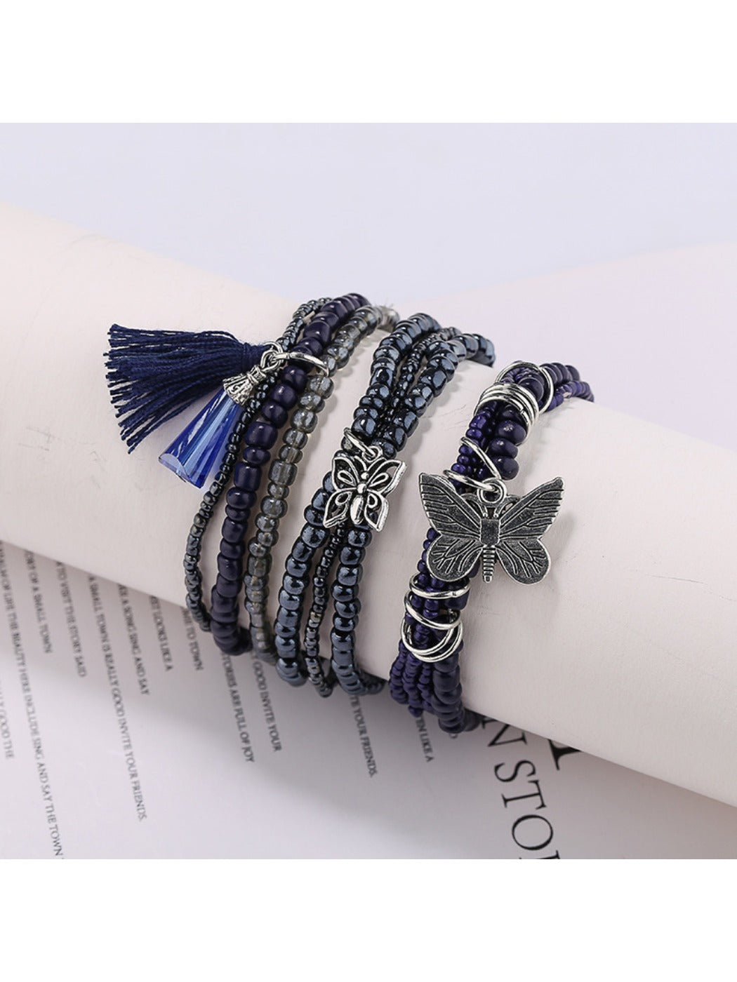 Beaded bracelet with butterfly pendant displayed on a white background