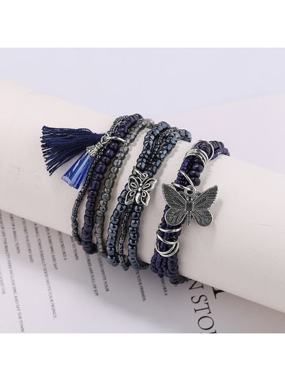 Beaded bracelet with butterfly pendant displayed on a white background