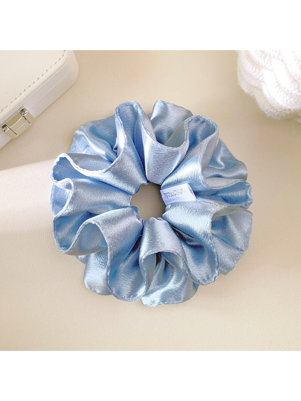 Close-up of Gifty solid satin double layer scrunchie in soft pink on white background