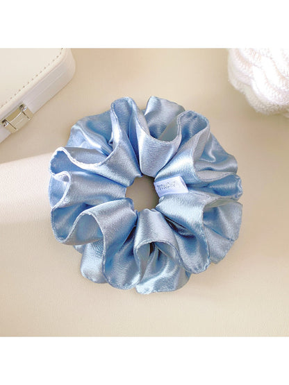 Close-up of Gifty solid satin double layer scrunchie in soft pink on white background