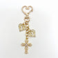 Vintage cross pendant keychain resting on a fabric background