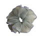Close-up of purple polka dot scrunchie showing fabric texture and trim detail