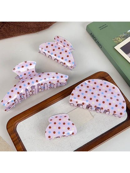Side view of Beau crescent pink claw clip with white polka dots highlighting clip teeth