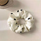 Gifty satin polka dot scrunchie neatly folded to highlight smooth satin material