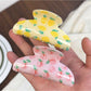 Side view of Beau half circle shark claw clip with vibrant fruit pattern
