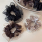 Glossy scrunchie styled on a wrist as a fashionable accessory
