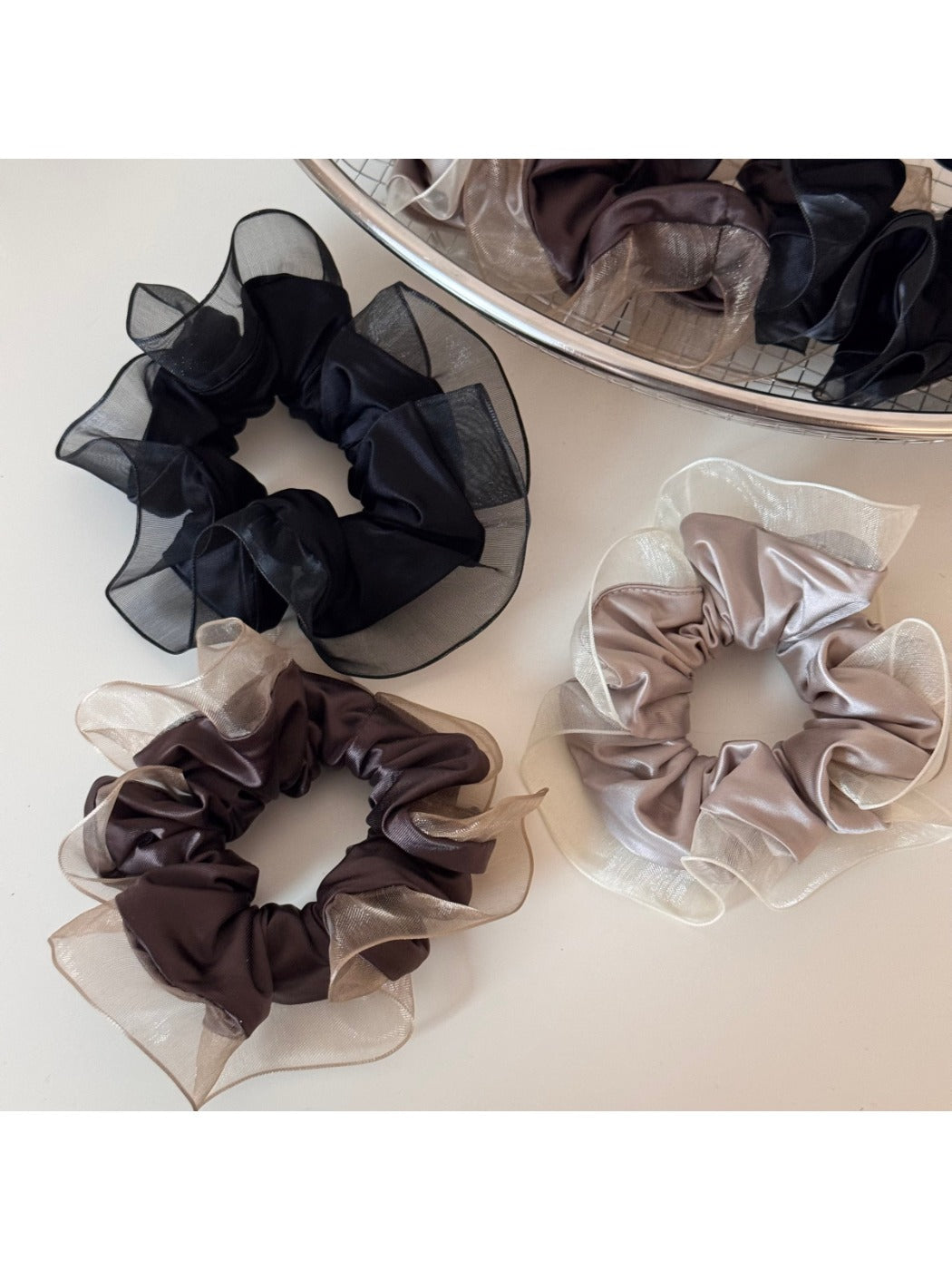 Glossy scrunchie styled on a wrist as a fashionable accessory