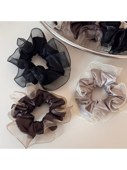 Glossy scrunchie styled on a wrist as a fashionable accessory