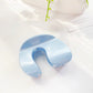 Beau arched hair claw clip photographed with soft shadows on plain background