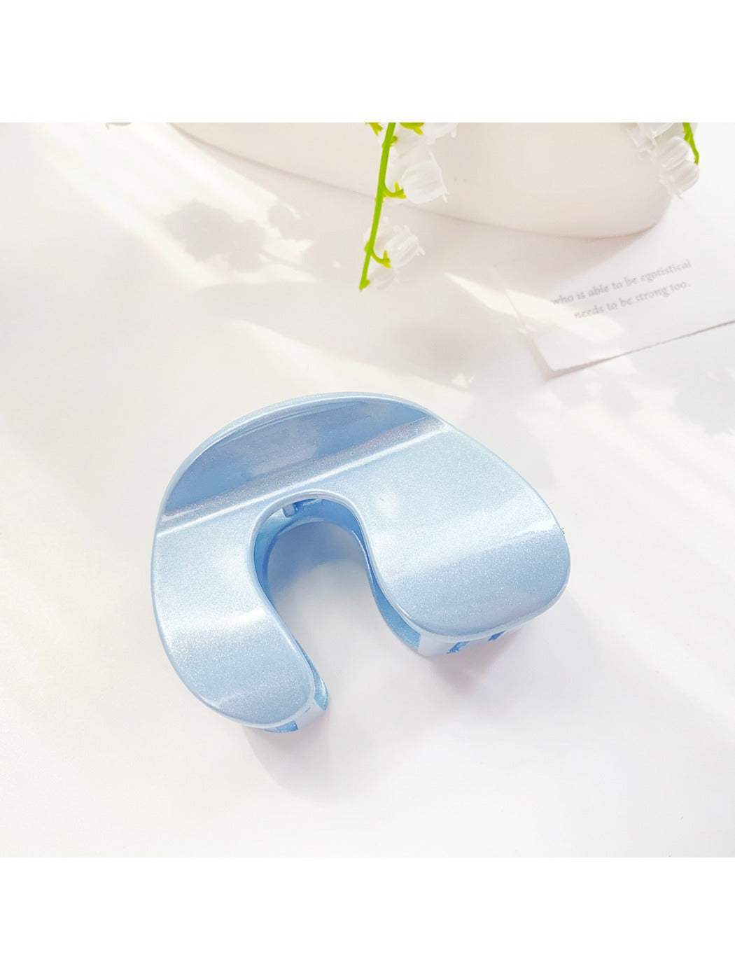 Beau arched hair claw clip photographed with soft shadows on plain background