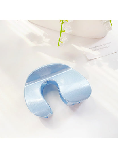 Beau arched hair claw clip photographed with soft shadows on plain background