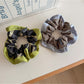 Gifty scrunchie displayed on a white background showing its vibrant color block pattern