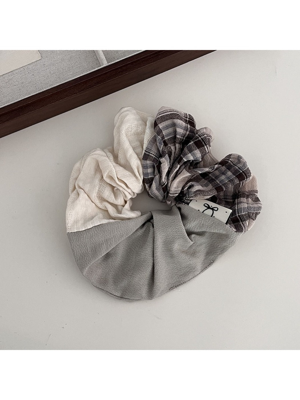 Gifty scrunchie styled on a model's wrist with vintage plaid pattern