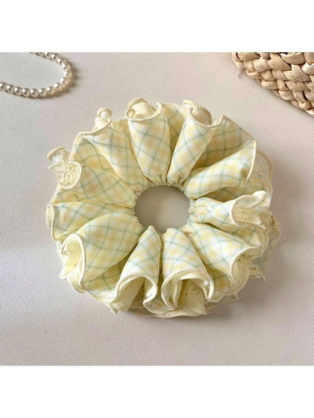 Close-up of yellow checkered scrunchie showing fabric pattern and elastic band