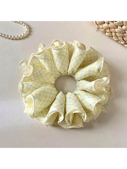 Close-up of yellow checkered scrunchie showing fabric pattern and elastic band