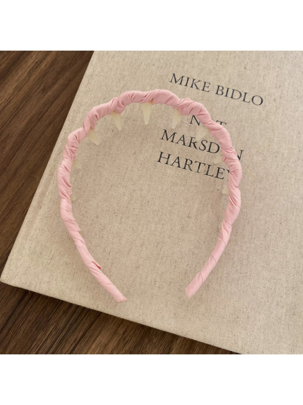 Gifty elegant wavy headband in pastel color displayed with soft lighting