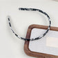 Side profile of Gifty acetate headband emphasizing silky smooth texture
