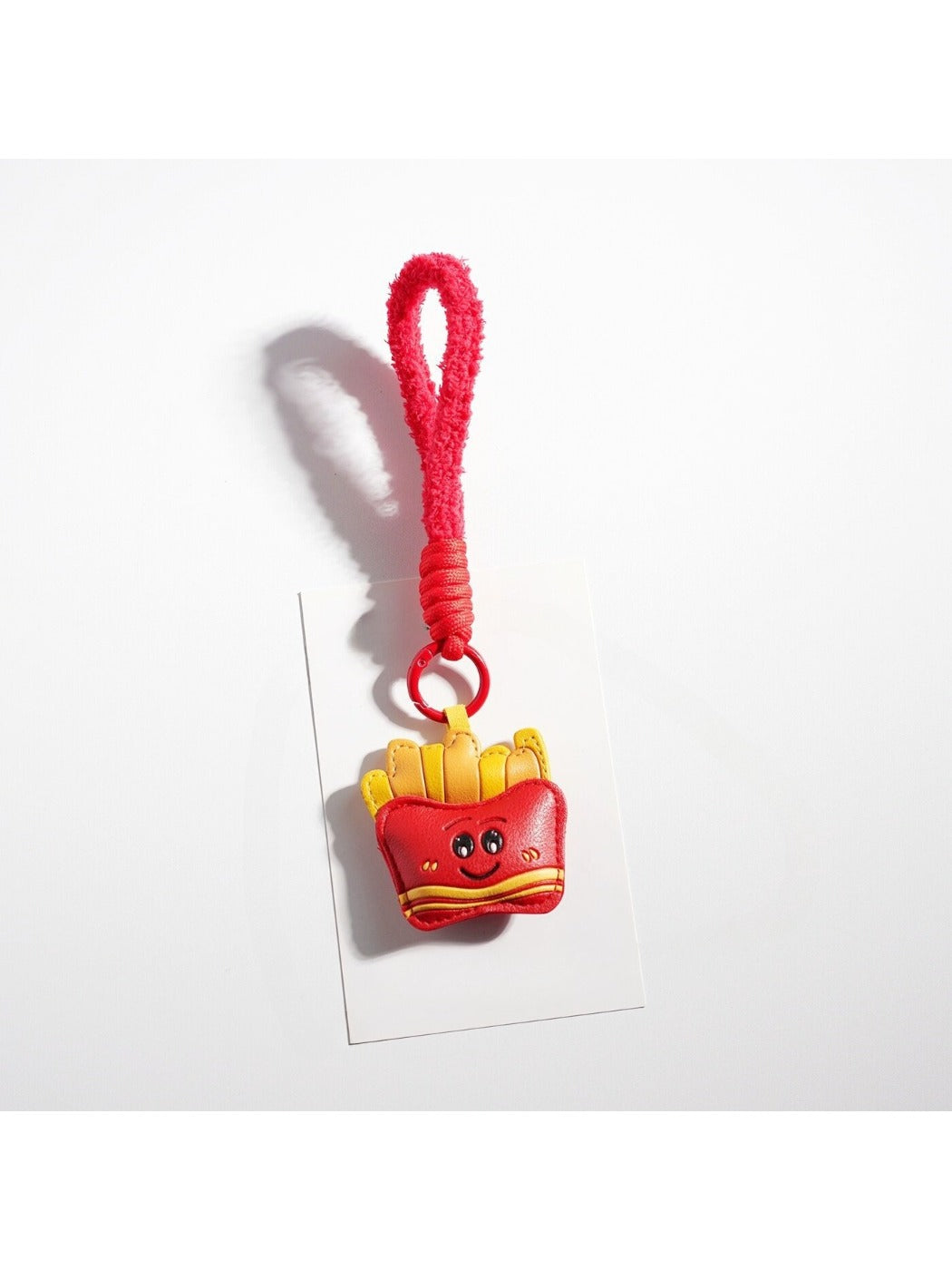 Keypus French fries and coffee cup keychain displayed on wooden surface