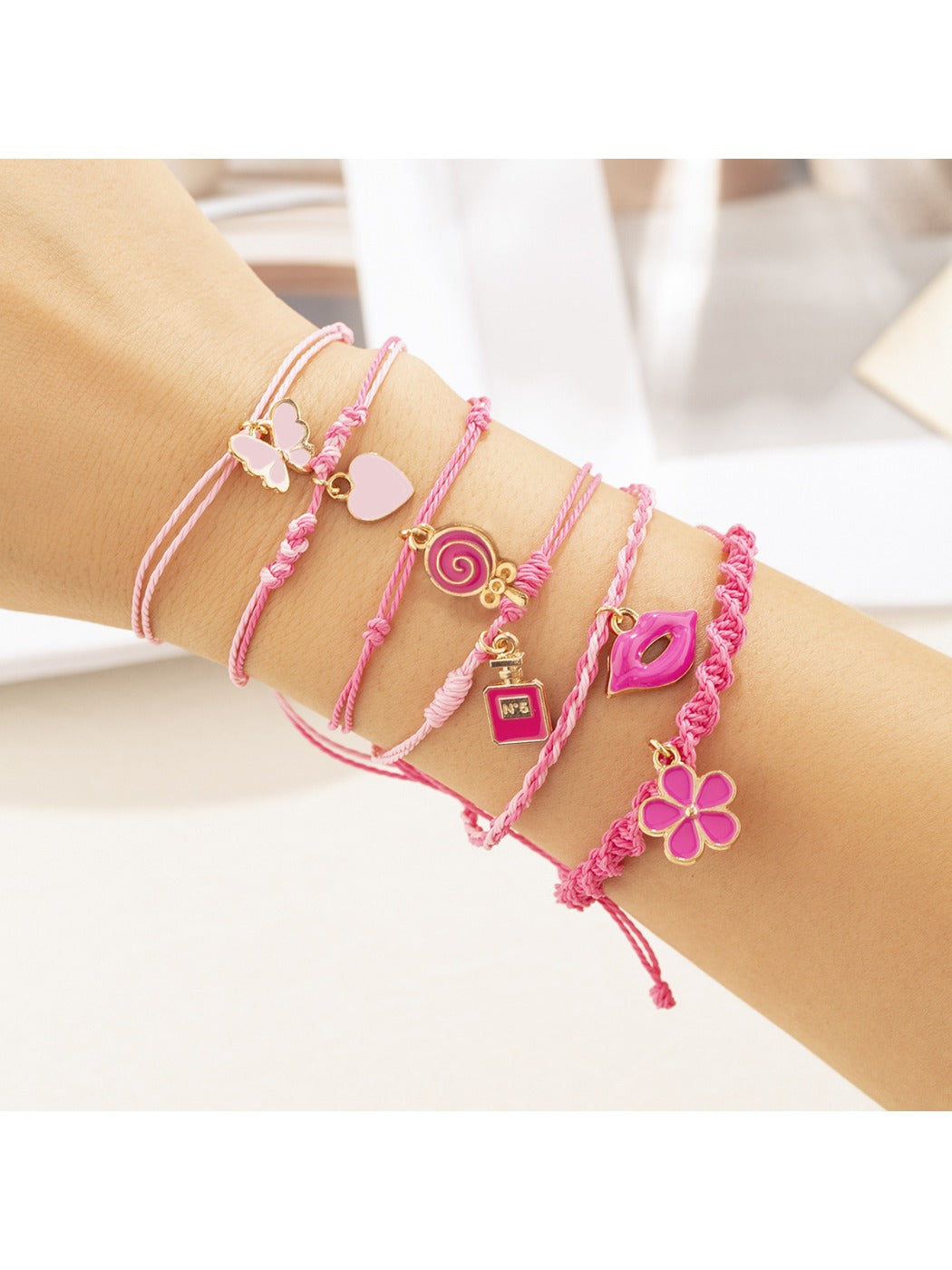 Lovra pink pendant layered bracelet worn on wrist, highlighting layered design and pink pendant