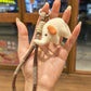 Elephant charm keychain hanging from a set of keys on a wooden surface