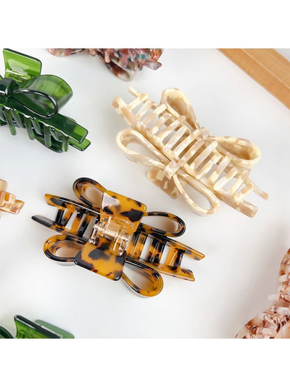 Beau bow shaped claw clip held in hand to show size and grip