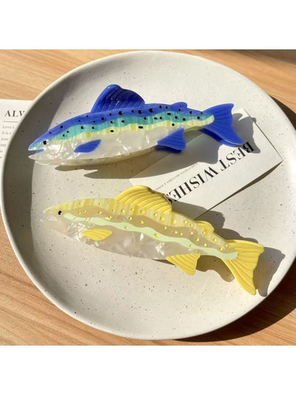 Beau salmon shaped hair claw clip held in hand to show size