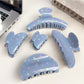 Blue star print hair claw clip with curved teeth on white background