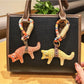 Fox charm keychain attached to a set of keys on a wooden surface