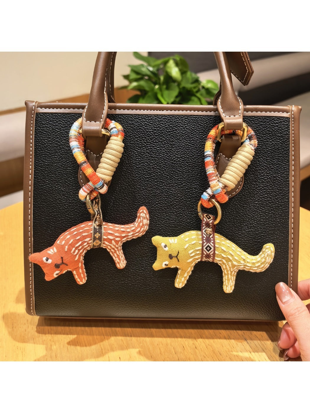 Fox charm keychain attached to a set of keys on a wooden surface