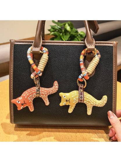 Fox charm keychain attached to a set of keys on a wooden surface