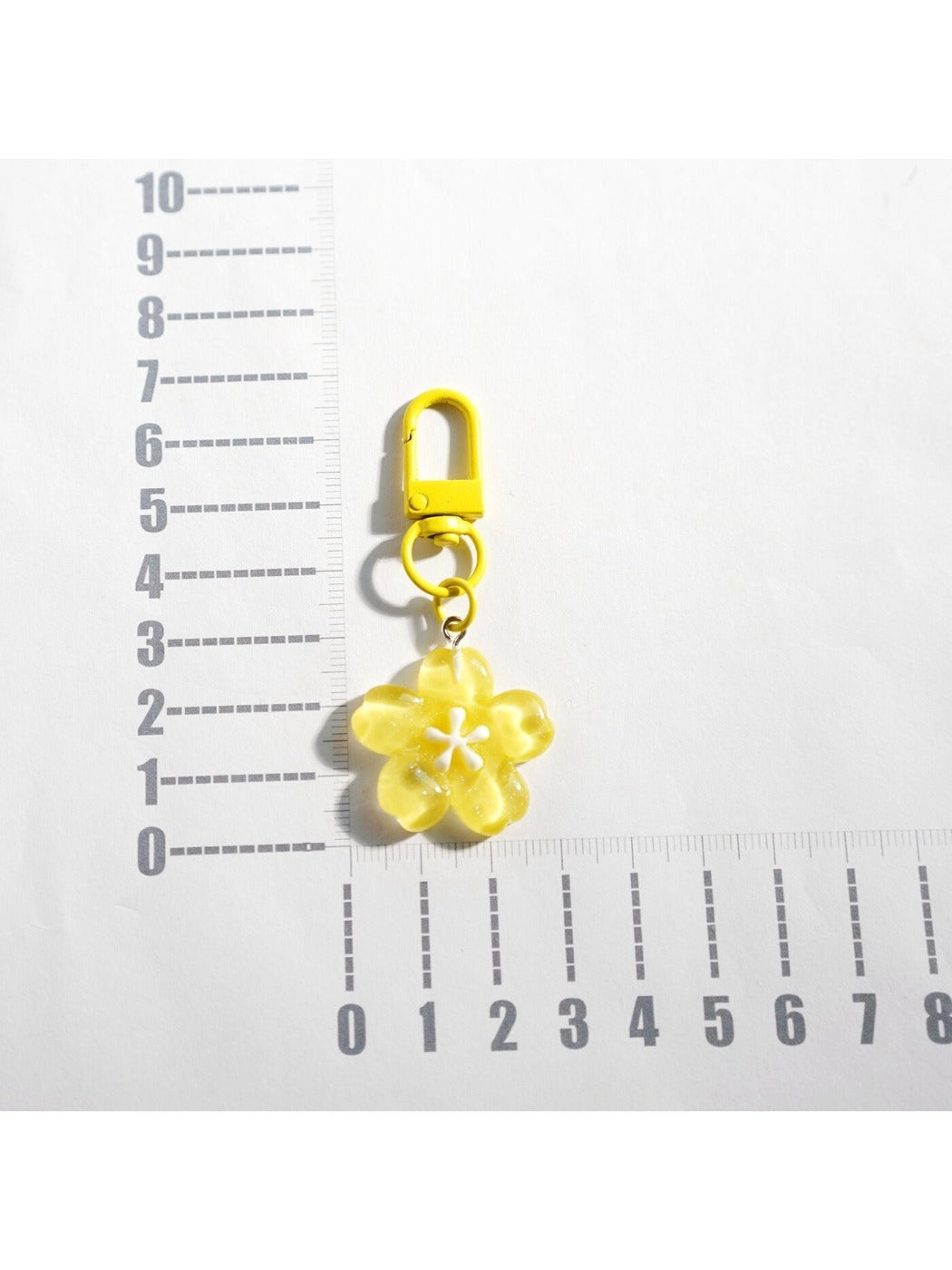 Flower keychain attached to a set of keys on a wooden surface