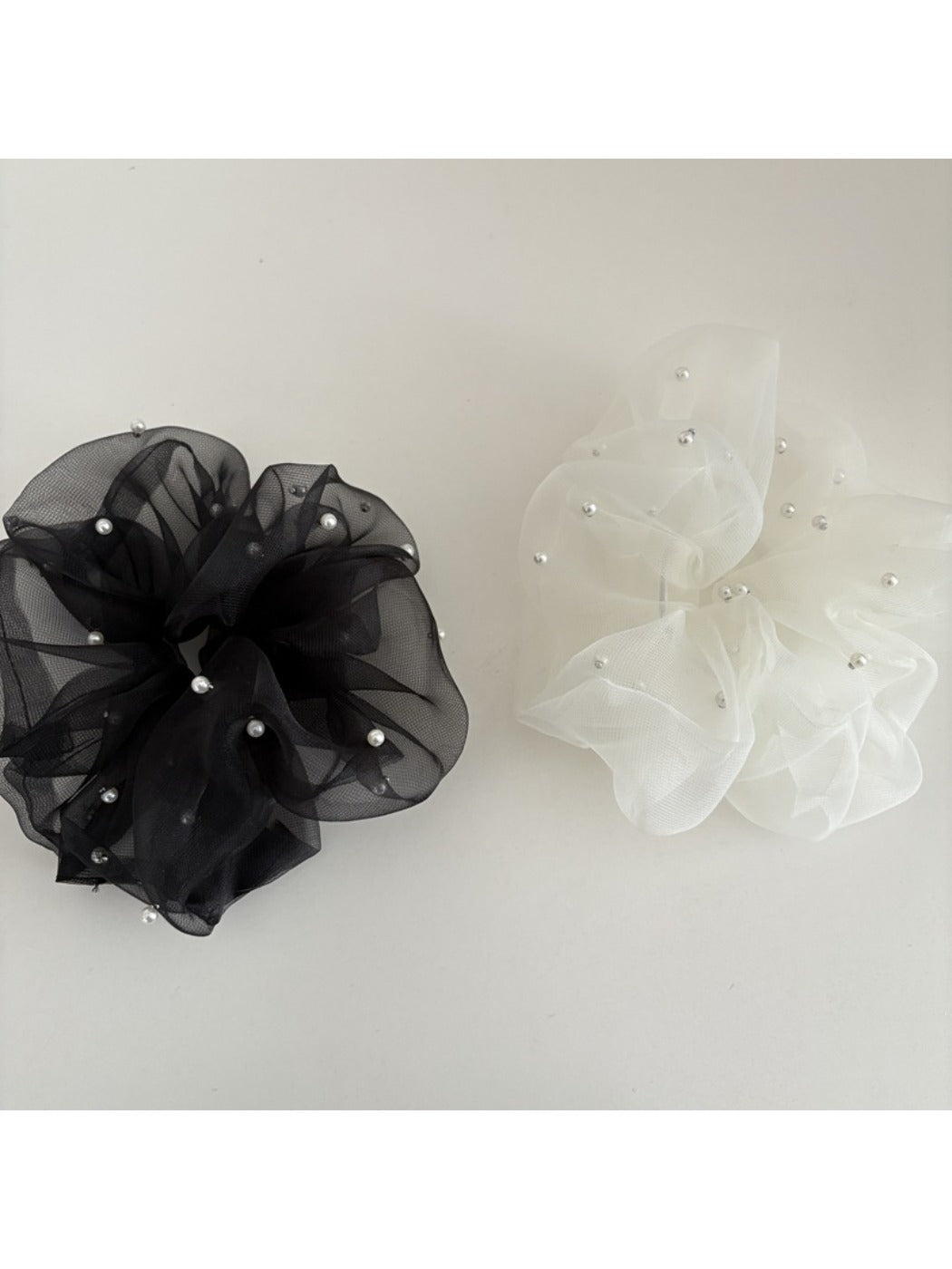Gifty tulle scrunchie styled on a wrist with soft folds and sheer fabric