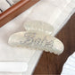 Beau crescent hair claw clip showing curved teeth and hinge mechanism