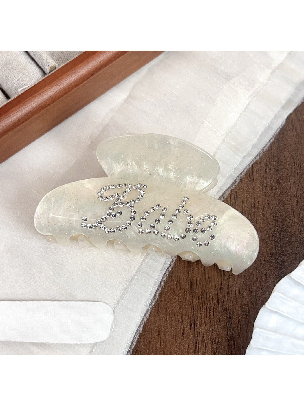 Beau crescent hair claw clip showing curved teeth and hinge mechanism