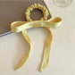 Gifty satin yellow ribbon bow scrunchie displayed flat showing bow detail