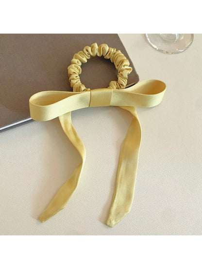 Gifty satin yellow ribbon bow scrunchie displayed flat showing bow detail