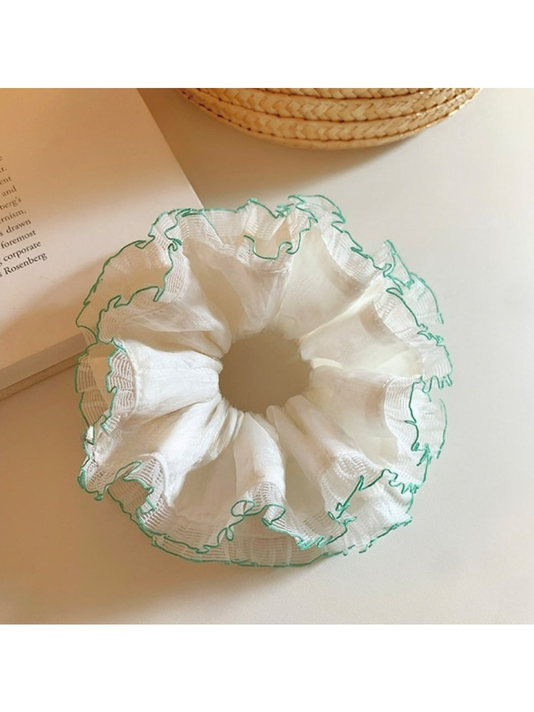 Close-up of white tulle fabric and green trim on double scrunchie