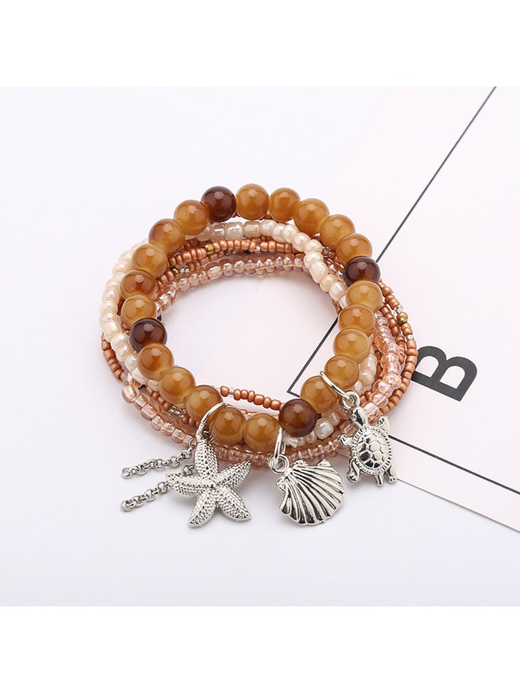 Lovra bracelet with multiple strands of small, round, colorful beads on a neutral surface
