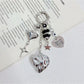 Close-up of silver heart charm on a minimalist keychain with a split ring