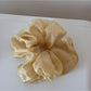 Detailed view of scrunchie fabric folds and floral print in soft colors