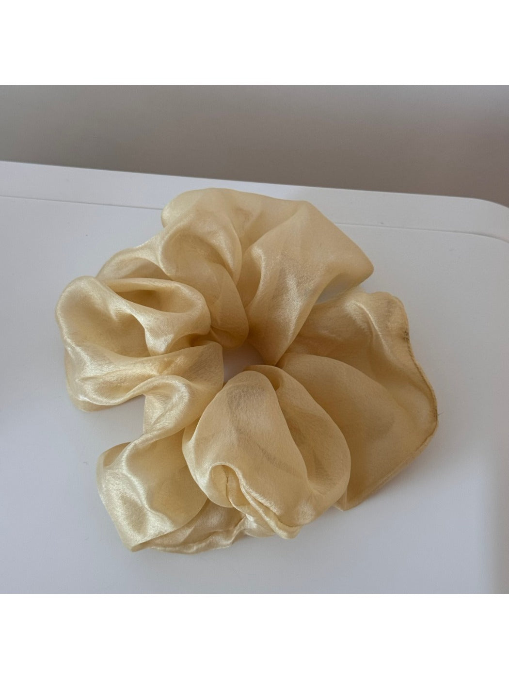 Detailed view of scrunchie fabric folds and floral print in soft colors
