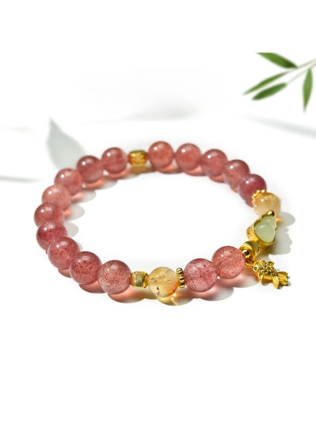 Goldfish pendant and crystal bead bracelet displayed on white background